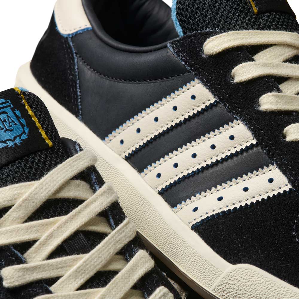 Close-up of Thrasher Magazine Glenburn Black Blue KH7384 Adidas Skateboarding Shoes featuring a black suede and leather upper, white laces, signature three stripes, blue stitching, and logo details for classic skate style.