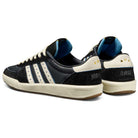 The Thrasher Magazine Glenburn Black Blue KH7384 Adidas Skateboarding Shoes feature a skate style, black and white design with three stripes, blue lining, cream heel tabs with two gold stars, and "THRASHER" text on the heel.