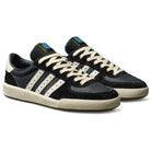 A pair of Thrasher Magazine Glenburn Black Blue KH7384 Adidas Skateboarding Shoes with black leather uppers, cream soles and stripes, cream laces, blue tongue tags, displayed side by side on a white background.