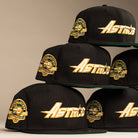 The La Morenita Black 45th Houston Astros New Era 5950 Fitted hat features a bold gold Astros logo, a green, yellow, and white 45th Anniversary side patch, and a flat brim.