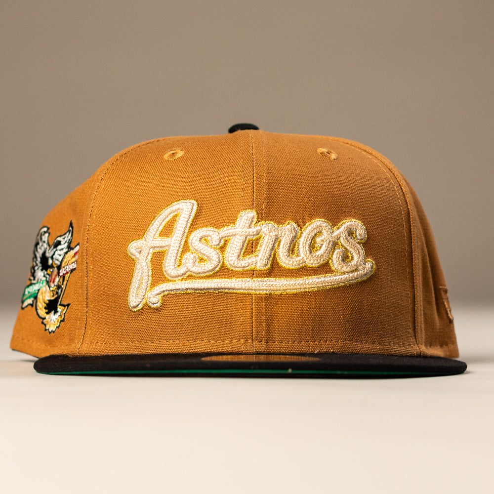 The El Gallo Canvas Bronze Black Houston Astros New Era 5950 Fitted Hat features bold Astros script on the front, a black brim, and a vibrant side patch—ideal for any Houston Astros fan.
