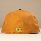 A bronze-black El Gallo Canvas Houston Astros 5950 Fitted New Era Hat is shown from the back, featuring a small, colorful embroidered MLB logo near the bottom on a plain, neutral background.