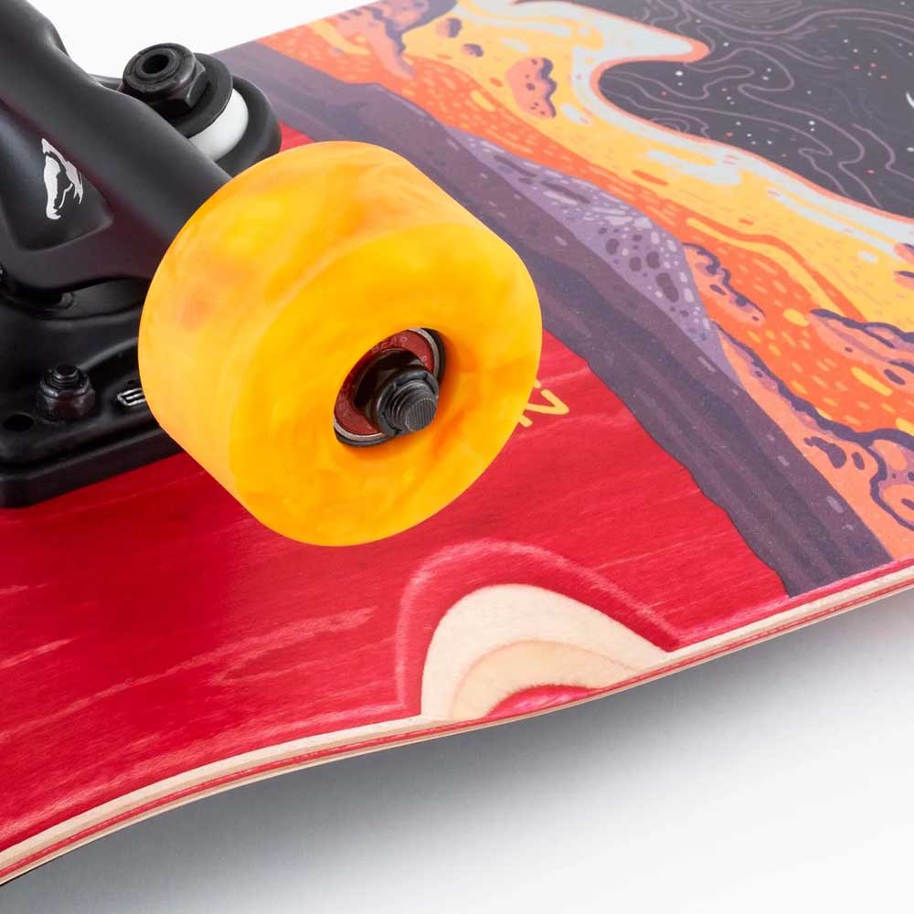 Close-up of the Tugboat Nightfall Landyachtz Complete Skateboard, featuring a bright yellow Hawgs wheel, metal truck, and a colorful Canadian maple deck with red, orange, and purple abstract patterns.