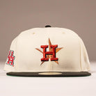 The Cougar 2.0 Houston Astros New Era Hat 5950 Fitted features a cream color, a red and black H with a gold star embroidered on the front, dark green brim, and side H logo for a standout look.
