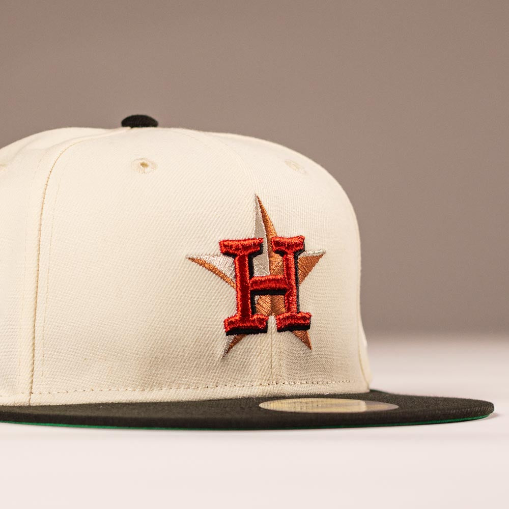The Cougar 2.0 Houston Astros New Era Hat 5950 Fitted features a cream color, black brim, and an embroidered red H over a gold star on the front for a classic Astros style.