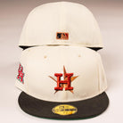 Two cream-colored The Cougar 2.0 Houston Astros New Era 5950 Fitted hats with black brims, featuring an orange and gold star with an H on the front, an H patch on the side, and a small MLB logo above the back opening.