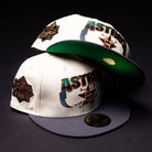 Two white Undaground 22WS Chrome Houston Astros New Era Hat 5950 Fitted caps, each featuring World Series patches and vibrant embroidered logos—one with a gray brim, the other showing a green underside—are stacked on a dark surface against a black background, embodying the distinct style of Chrome Undaground.