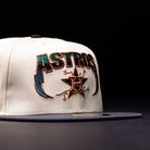 The Undaground 22WS Chrome Houston Astros New Era Hat 5950 Fitted, a white and black fitted cap by New Era, features a bold, colorful embroidered ASTROS logo with a star and H on the front and is displayed against a dark Chrome Undaground backdrop.