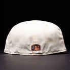 The Undaground 22WS Chrome Houston Astros New Era Hat 5950 Fitted is shown from the back in white, featuring a small rectangular patch with a black and orange logo, set against a dark background.