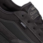 Close-up of VN000D85CC81 Skate Curren Caples Charcoal Black Vans shoe, highlighting the Vans logo tag, suede and fabric textures, detailed stitching, tongue with Duracap underlays for durability, and Curren Caples branding.