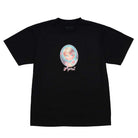 The Vanity Tee Black April Skateboards T-Shirt features a pastel illustration of a blonde doll-like girl with pink flowers, framed in an oval, and "April" written in cursive below.