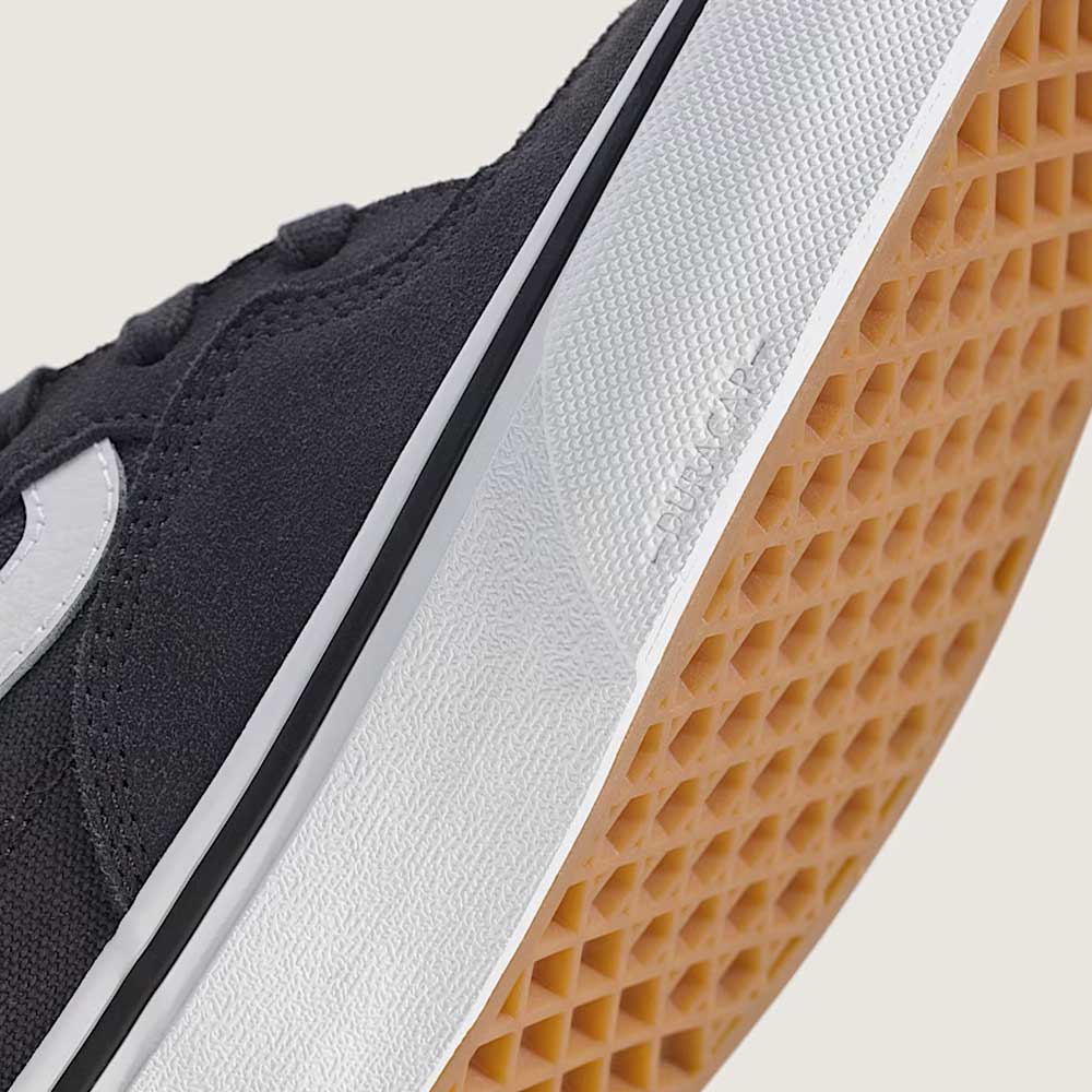 Close-up of the Vans Rowan Charcoal Gray VN0A5JICH911 suede skate shoe, featuring a black and white color scheme with a durable gum waffle-patterned sole—showcasing classic design elements valued in sturdy skate footwear.