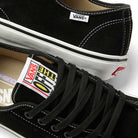 Close-up of the Vans Skate AVE Classic Black White VN000Y1NBA2 Suede Skateboard Shoes, featuring a black suede upper with white soles. The Vans logo appears on the side tag and on the tongue, which also displays the Off The Wall label. These sneakers showcase signature Wafflecup construction for superior support and are finished with black laces.