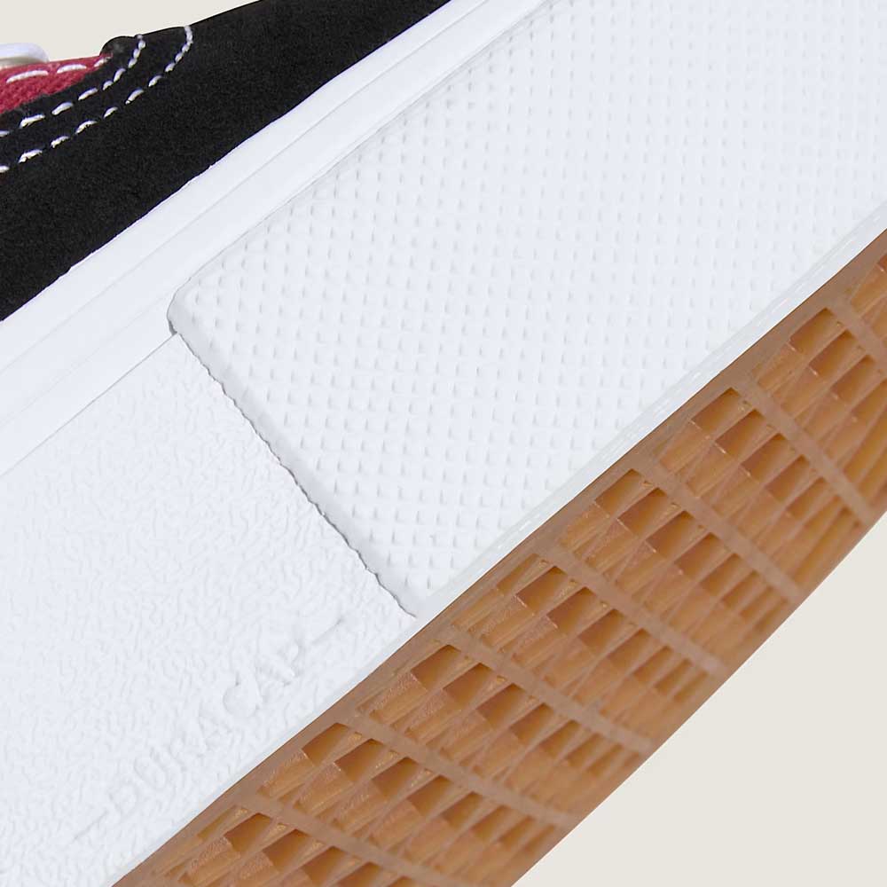 Close-up of the Vans Skate Era Black Dark Red VN000ECRBDK1 suede shoe, featuring a white midsole, textured white rubber detail, gum outsole, and visible white stitching on the upper for stylish durability in skateboarding.