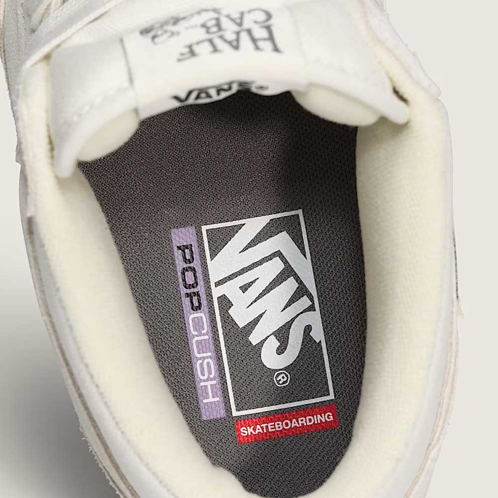 Close-up view of the grey insole on Vans Skate Half Cab Marshmallow White VN0A5FCDCA suede skateboard shoes, featuring Vans, PopCush impact protection, and Skateboarding logos. The tongue shows "HALF CAB 33." Ideal for comfort and style.