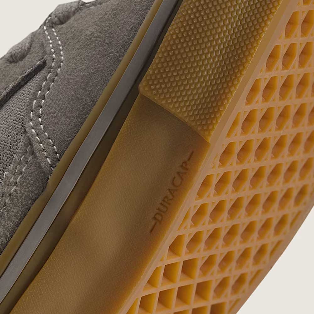 Close-up of the Vans Skate Half Cab Walnut Gum VN0A5FCD77J1, a grey suede skateboard shoe with a gum waffle-pattern sole and DURACAP embossed on the side, ideal for skateboarding.