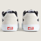 Back view of two Vans Skate Kyle Walker Wafflecup White Gunmetal VN000DA4XQL1 suede and rubber shoes with gray accents, showcasing PopCush insoles and the iconic red Vans Off The Wall logo on the rubber heels, set against a beige background.