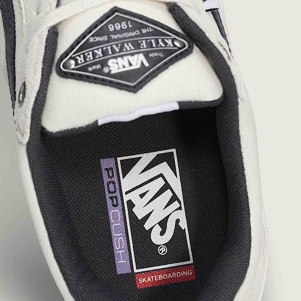 Close-up of the Vans Skate Kyle Walker Wafflecup White Gunmetal VN000DA4XQL1 suede rubber shoe, highlighting the PopCush Skateboarding label on the insole and a Kyle Walker patch on the tongue. The shoe features a mostly white design with black and grey (gunmetal) accents.