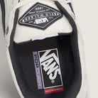 Close-up of the Vans Skate Kyle Walker Wafflecup White Gunmetal VN000DA4XQL1 suede rubber shoe, highlighting the PopCush Skateboarding label on the insole and a Kyle Walker patch on the tongue. The shoe features a mostly white design with black and grey (gunmetal) accents.