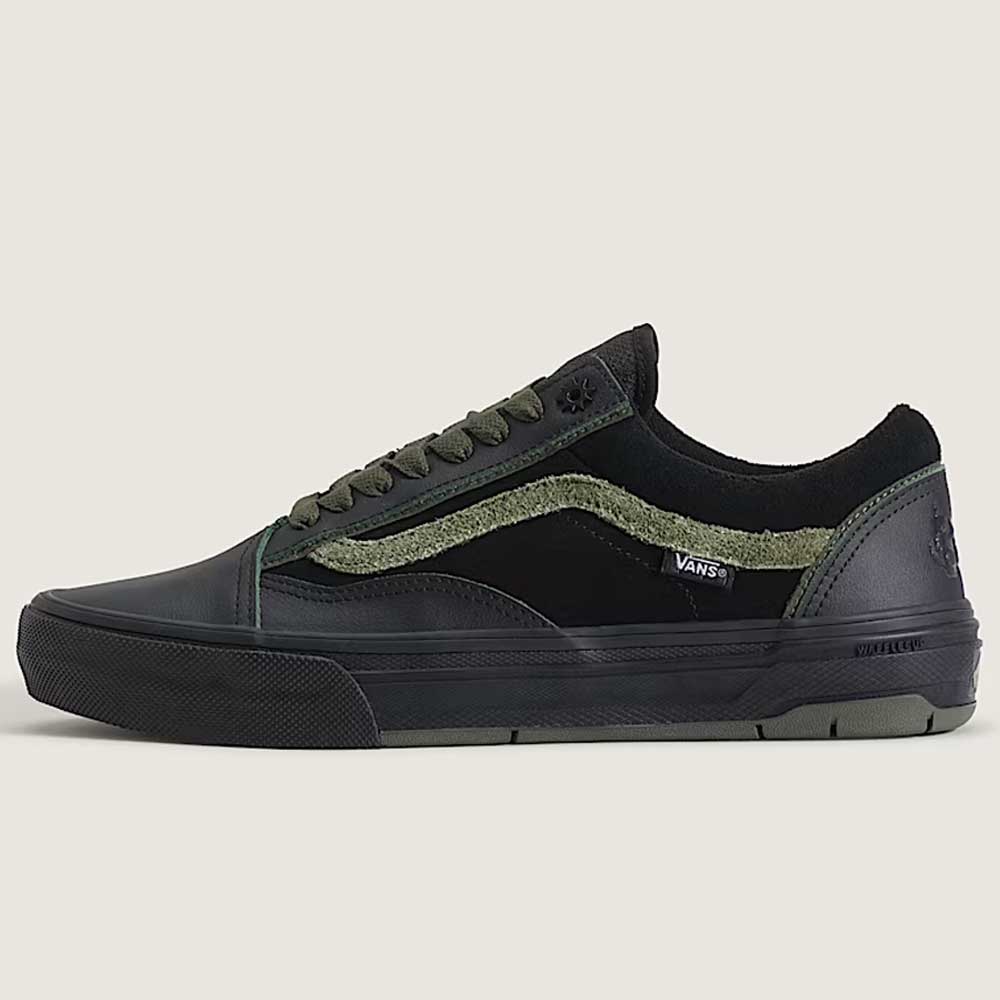 The Vans Skate Half Cab Walnut Gum VN0A5FCD77J1 suede skateboard shoes feature black and dark green suede panels, olive green laces, a textured green stripe, PopCush impact protection, and a black rubber sole on a light background.