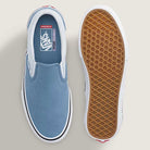 A pair of Vans Skate Slip On VN000EG5DSB1 Dusty Blue Suede Shoes are shown from above and below: the left shoe displays the top view, highlighting the light blue suede upper, while the right shoe reveals the classic brown waffle-patterned sole. Designed for durability and reliable skateboarding performance, these iconic slip-ons showcase timeless style and functionality.
