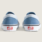 Rear view of two Vans Skate Slip On VN000EG5DSB1 Dusty Blue Suede Shoes featuring light blue suede uppers, white soles, and the classic red “Off the Wall” Vans logo on the heels, set against a neutral background. Engineered for skateboarding performance, these durable shoes combine iconic style with exceptional functionality.