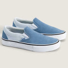 The Vans Skate Slip On VN000EG5DSB1 Dusty Blue Suede Shoes feature a blue and white colorway with white soles, a black stripe around the midsole, and a small blue checkerboard detail near the elastic—designed for both style and skateboarding performance.