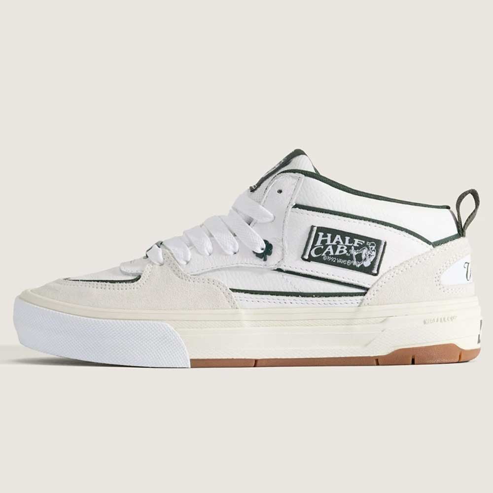 The Vans Skate Half Cab Walnut Gum VN0A5FCD77J1 features a white suede and canvas upper with green accents, HALF CAB label, white laces, a white sole with gum bottom, and PopCush impact protection for skateboarding.