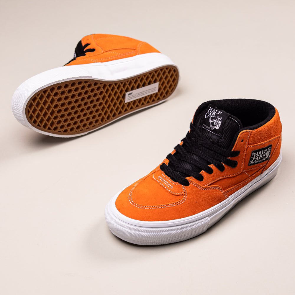 A pair of Skate Half Cab Flame White VN0A5FCDSFZ1 Vans suede skate shoes with DuraCap and PopCush footbeds, white soles, and black laces; one shoe is upright, the other shows its signature waffle-patterned sole on a light background.