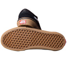 A pair of Vans Skate Old Skool Black Gum White VN000EDNB9K1 suede rubber shoes: one lies on its side showing the brown waffle-patterned sole, the other upright with the red Vans logo on the heel—classic skate style.