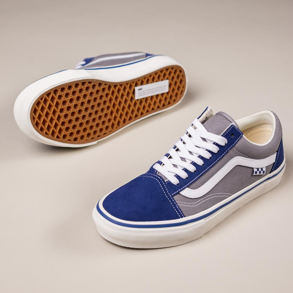 The Vans Skate Old Skool Blue Gray VN000EDNY241 shoes feature blue, gray, and white suede panels, white laces, and a gum rubber waffle sole—one shoe upright and one on its side to show the sole. Ideal for skateboarding.