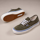 The Suede Canvas Mossy Olive Authentic VN0A5FC8FR11 Vans Skate Skateboarding Shoes feature olive green canvas, white laces and soles, blue accents near the sole, and gum rubber waffle-pattern outsoles displayed on a neutral background.