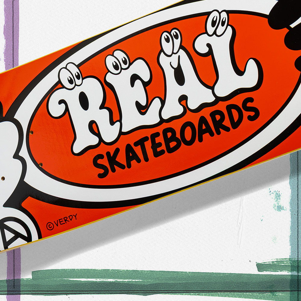 The Verdy Oval 8.06 Real Skateboard Deck Skateshop Day features a bold orange and white design with "REAL SKATEBOARDS" in cartoon-style letters, eyes, and the artist's signature—ideal for collectors of exclusive and limited skateboard drops.