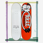 Two Verdy Oval 8.38 Real Skateboard Decks for Skateshop Day are shown: one is white with “REAL x Verdy Skate Shop Day 2023” in black, and the other is orange with cartoon art and bold “REAL SKATEBOARDS” lettering.