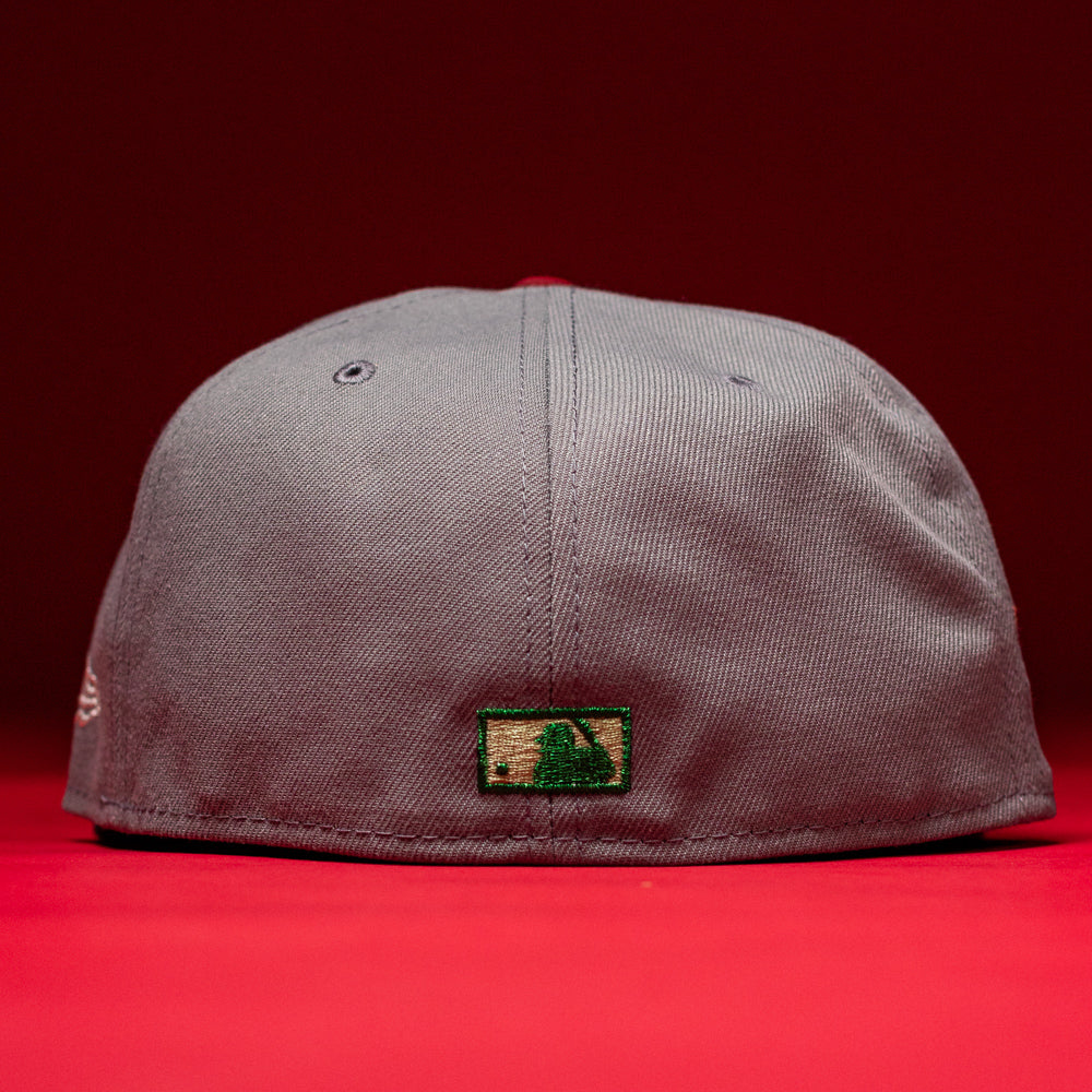 A Days B4 WS05 Misty Black Houston Astros New Era Hat 5950 Fitted is shown from the back against a red background, featuring a small green and beige rectangular patch with a dark green logo near the bottom edge for a subtle nod to Houston Astros style.