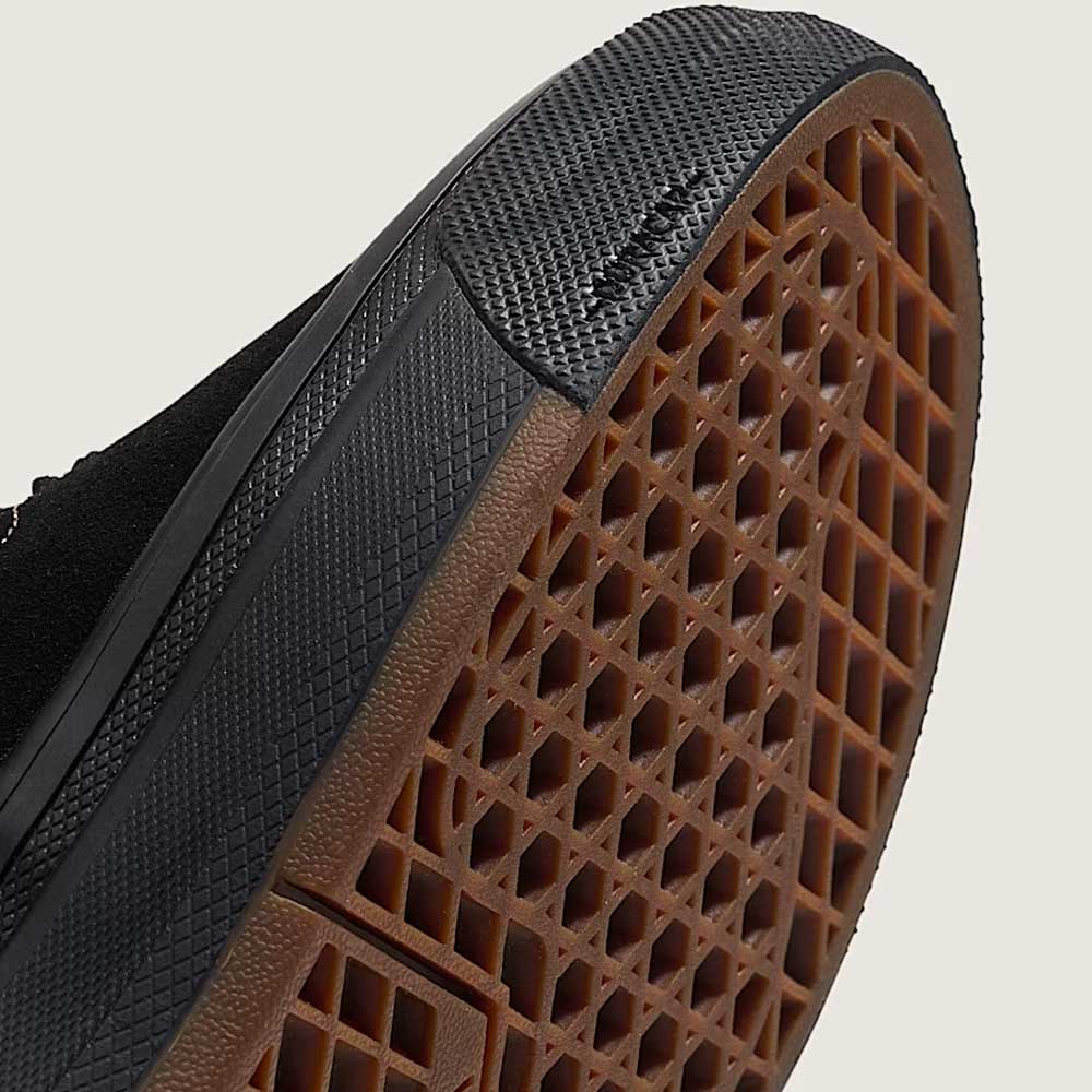 Close-up view of the Wafflecup-patterned brown rubber sole and black toe cap of the Vans Wafflecup Half Cab Black Peyote VN000D9ZOUK1 suede skate shoe, shown against a plain light background.