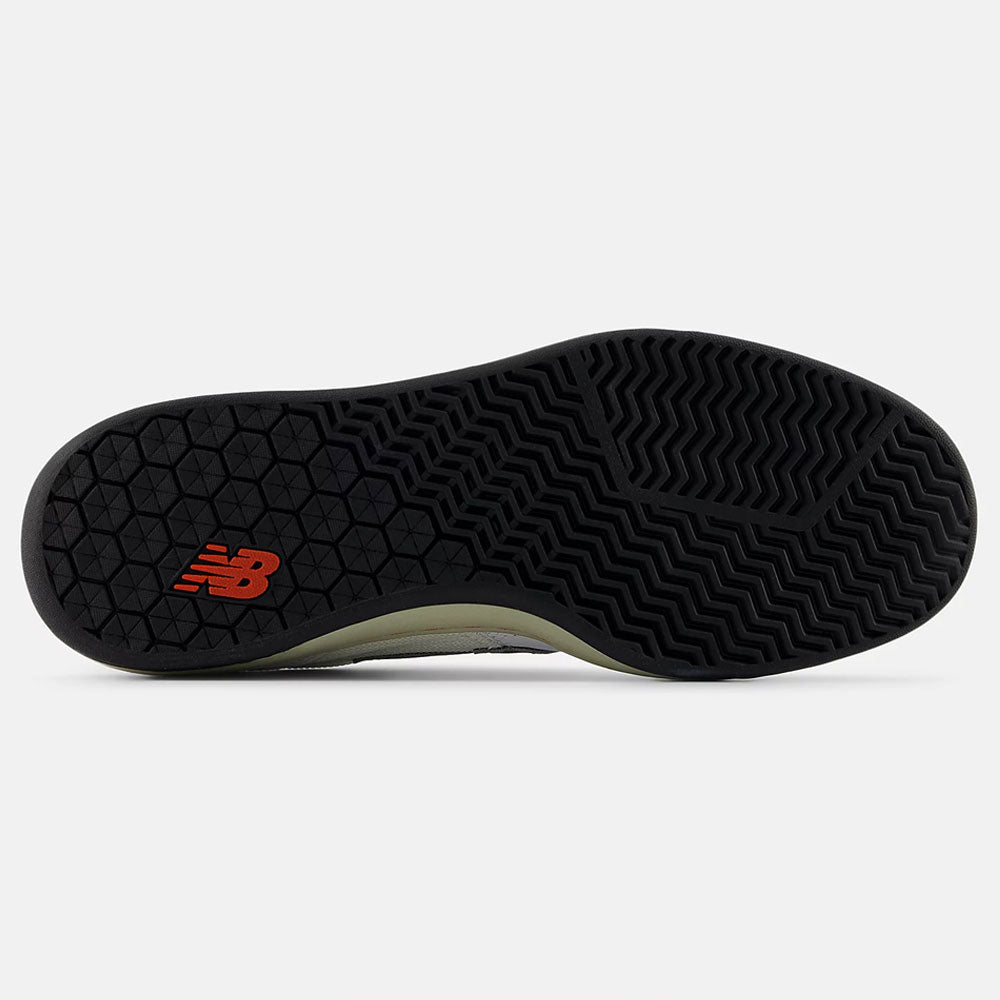 The image shows the black rubber outsole of the White Black 440 NO2 New Balance Numeric Suede Skateboarding Shoe, with a red New Balance logo near the heel and zigzag and wavy grooves for traction.