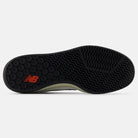 The image shows the black rubber outsole of the White Black 440 NO2 New Balance Numeric Suede Skateboarding Shoe, with a red New Balance logo near the heel and zigzag and wavy grooves for traction.