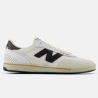 The White Black 440 NO2 New Balance Numeric Suede Skateboarding Shoes feature a white and beige upper, large black N logo, black heel accent, perforated details, ABZORB midsole for comfort, and a durable cream rubber sole with an orange stripe.