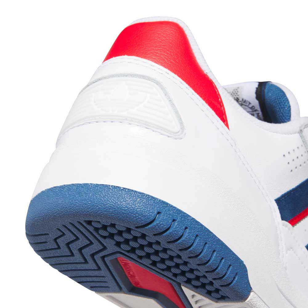 Close-up of the heel of a White Brown Tekkira HQ4814 Adidas Skateboarding Suede Leather Shoe featuring red, blue, and navy accents, a textured blue outsole, Lightmotion cushioning, and a subtle embossed logo on the back.