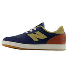 The YOUTH 440 NVB New Balance Numeric Suede Skateboarding Shoes feature a navy blue suede upper with tan and rust orange accents, white laces, and a white sole. Built for durability on the skateboard, these shoes have a reinforced toe cap for added protection, a prominent tan N logo on the side, perforated detailing at the heel, and a supportive rubber cupsole designed for lasting wear.