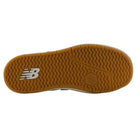 The sole of the YOUTH 440 NVB New Balance Numeric Suede Skateboarding Shoes features a gum-colored, textured tread pattern with the white NB logo on the left side, crafted with a durable rubber cupsole—making these an excellent choice for long-lasting skate shoes.