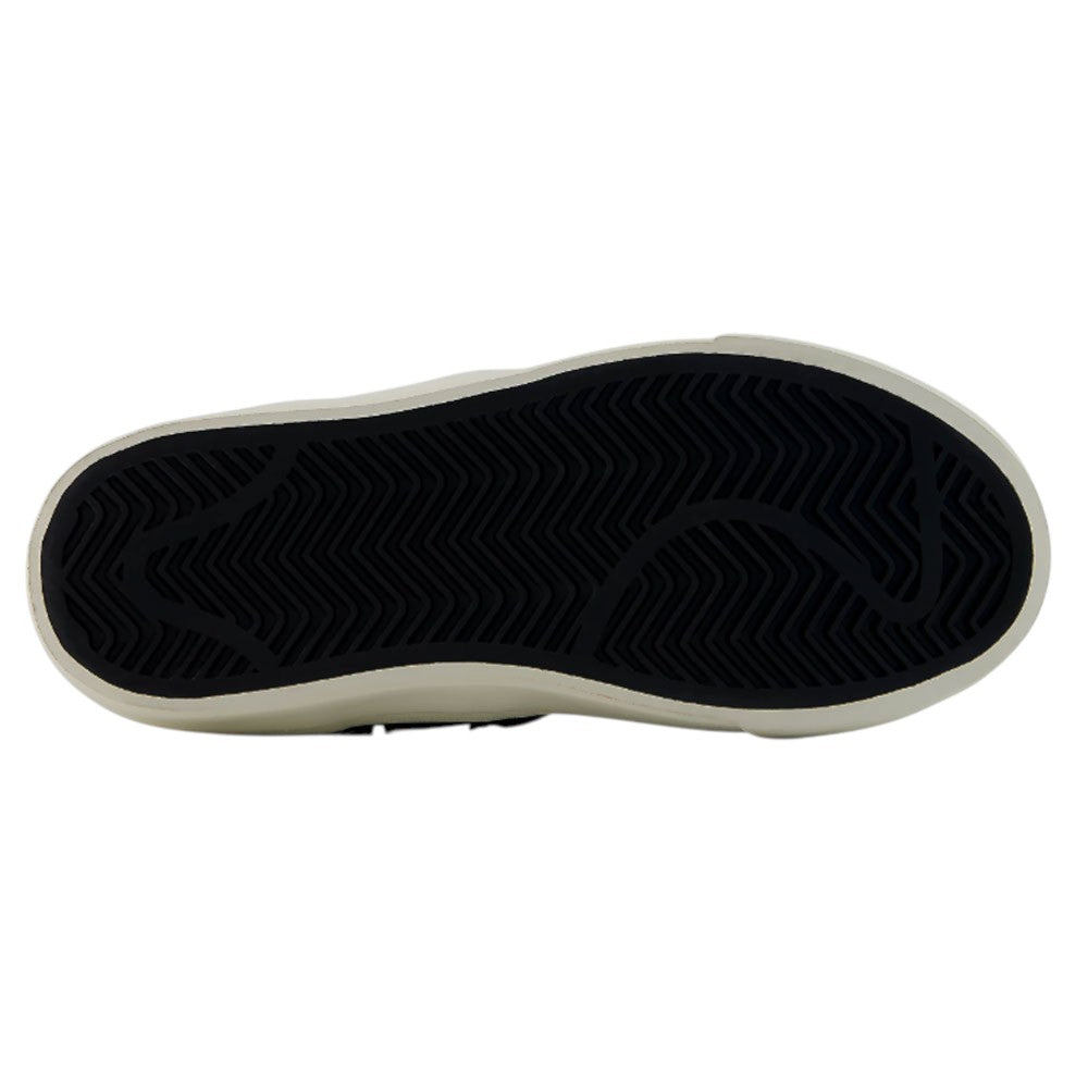 The image shows the black rubber sole of the YOUTH Jamie Foy Cup 306 TWY New Balance Numeric Suede Skateboarding Shoes, featuring a white outer edge. The tread pattern consists of zigzag and wavy lines, designed for excellent grip—ideal for a kids’ skate shoe inspired by pro skater Jamie Foy.