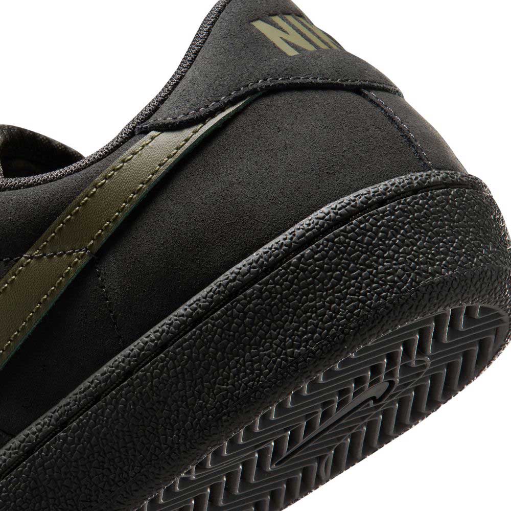 Close-up of the heel and side of the Nike SB Zoom Tennis Classic HF7386200 in Deep Pewter/Medium Olive suede, featuring a textured rubber sole, olive stripe detail, partial Nike branding on the back, and a cushioned insole for comfort.