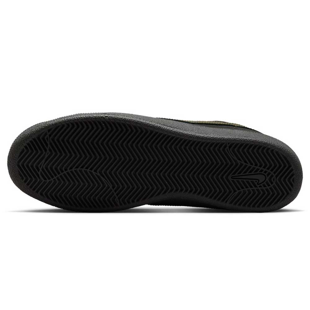The image shows the black rubber sole of the Zoom Tennis Classic HF7386200 Deep Pewter Medium Olive Suede Nike SB Skateboarding shoe, featuring a herringbone tread pattern and a small embossed Nike Swoosh near the heel.
