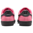 The Nike SB Zoom Tennis Classic IO8394600 Hyper Pink Black skate shoes feature black soles and heels, gothic-style black lettering on the back, pink interiors, and a rear view highlights their striking design.