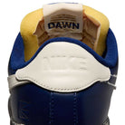 Close-up of the heel of a blue Zoom Tennis Classic x Rassvet IO9846400 Nike SB skate shoe with a white leather tab embossed with NIKE, yellow and blue inner lining, visible tongue with text, and cushioned insole for comfort.