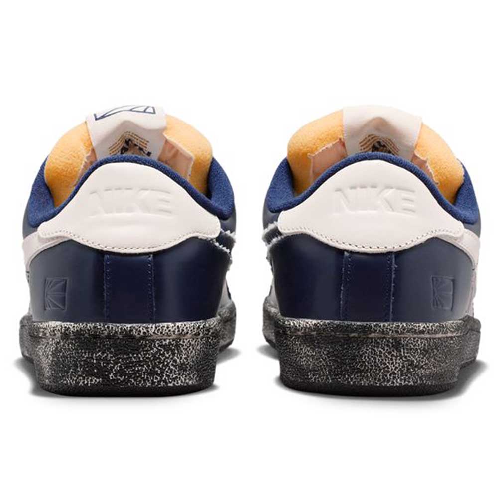 Rear view of Zoom Tennis Classic x Rassvet IO9846400 Blue Void Sail Nike SB leather skateboarding shoes, featuring blue and white colors with orange details, black soles, embossed Nike heels, and comfortable insoles.