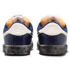 Rear view of Zoom Tennis Classic x Rassvet IO9846400 Blue Void Sail Nike SB leather skateboarding shoes, featuring blue and white colors with orange details, black soles, embossed Nike heels, and comfortable insoles.