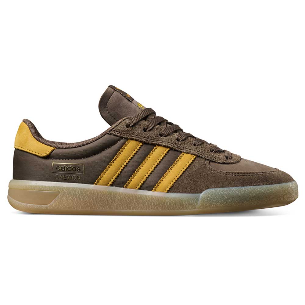 The Daewon Song Glenburn Brown Yellow KZ8777 Adidas Skateboarding Shoes feature a mix of suede and leather in brown and yellow, iconic three yellow stripes, a translucent rubber sole, and DAE 801 along with adidas branding on the side—perfect for anyone after street-ready sneakers with standout style.